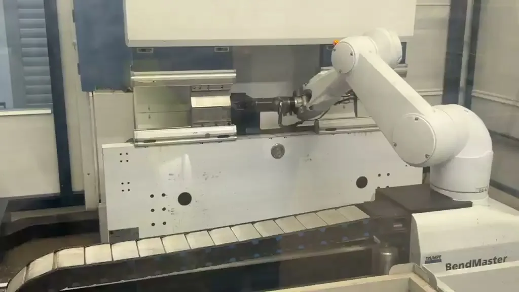 Roboter legt ein Blechteil in die Abkantpresse einer Biegezelle