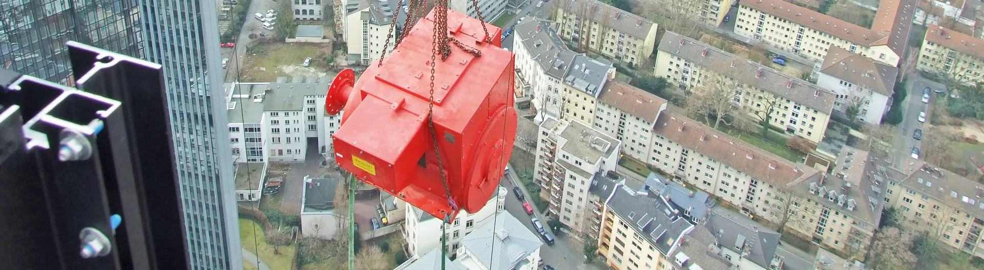 Generator eines Notstromaggregats am Kran hoch über Frankfurt