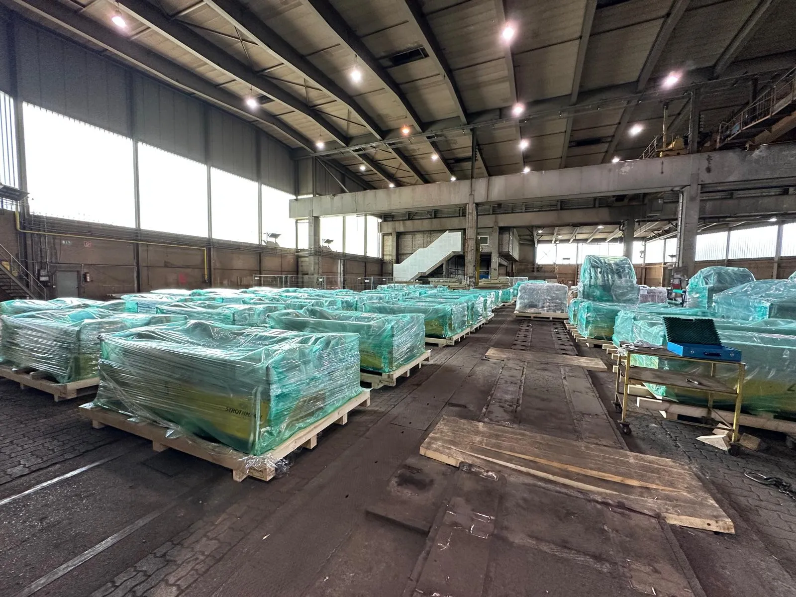Für den Export verpackte Maschinen auf Holzgestellen in einer großen Halle